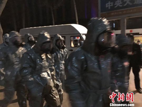 十几名身着防护服的人员头戴面具进入事发地。　胡健 摄